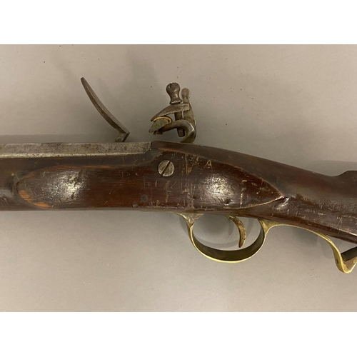 511 - A 19TH CENTURY FLINTLOCK LONG GUN. With a 75cm octagonal barrel, with unmarked flintlock mechanism, ... 