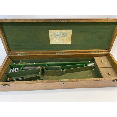 565 - A J. PURDEY OAK GUN CASE AND ACCESSORIES. A large oak gun case, the interior of the lid with a paper... 