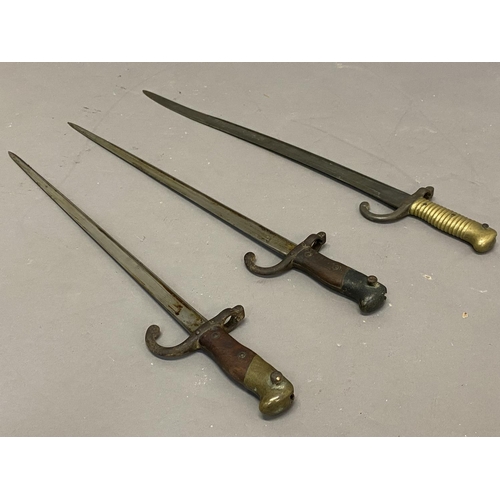 642 - THREE SIMILAR FRENCH SWORD BAYONETS AND SCABBARDS. A French bayonet, with a 52.5cm pointed blade, th... 