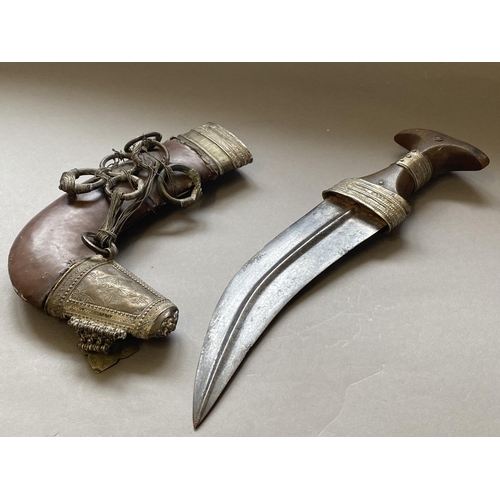 650 - AN ARBIAN KATAR TYPE DAGGER AND SHEATH. With a silver coloured wire bound horn handle and 21cm curve... 