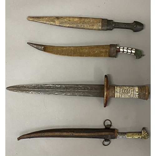 653 - A COLLECTION OF FOUR EASTERN KNIVES AND SCABBARDS. A steel bladed knife with a 25cm tapering pointed... 