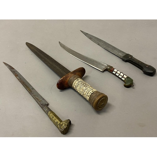 653 - A COLLECTION OF FOUR EASTERN KNIVES AND SCABBARDS. A steel bladed knife with a 25cm tapering pointed... 