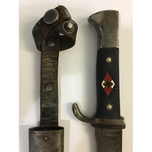 664 - A SECOND WORLD WAR HITLER YOUTH KNIFE AND SCABBARD. With a 13.5cm sharpened pointed blade with motto... 