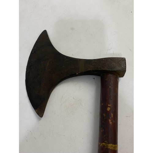 670 - A TRIBAL AXE WITH LONG PAINTED HANDLE. The axe head with a rounded cutting edge and impressed star d... 