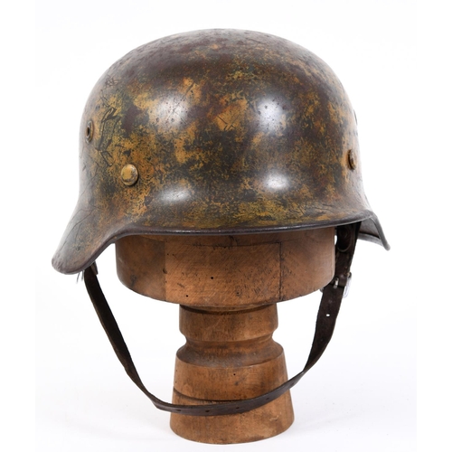 683 - AN M40 LUFTWAFFE HELMET WITH PAINTED CAMOUFLAGE FINISH. A Second World War or later M40 type steel h... 