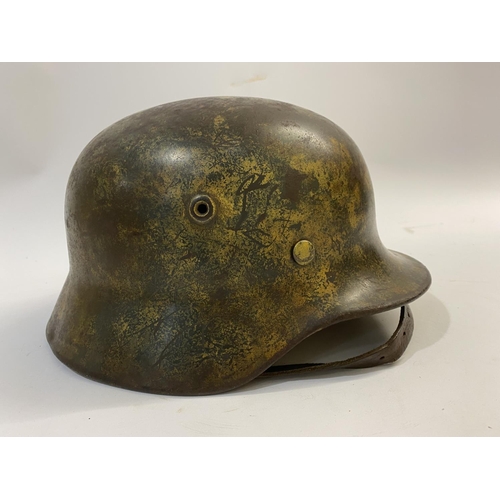 683 - AN M40 LUFTWAFFE HELMET WITH PAINTED CAMOUFLAGE FINISH. A Second World War or later M40 type steel h... 