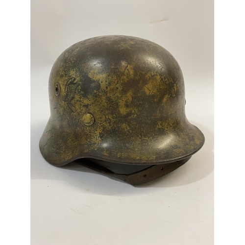 683 - AN M40 LUFTWAFFE HELMET WITH PAINTED CAMOUFLAGE FINISH. A Second World War or later M40 type steel h... 