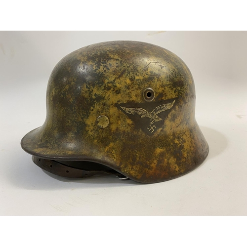 683 - AN M40 LUFTWAFFE HELMET WITH PAINTED CAMOUFLAGE FINISH. A Second World War or later M40 type steel h... 