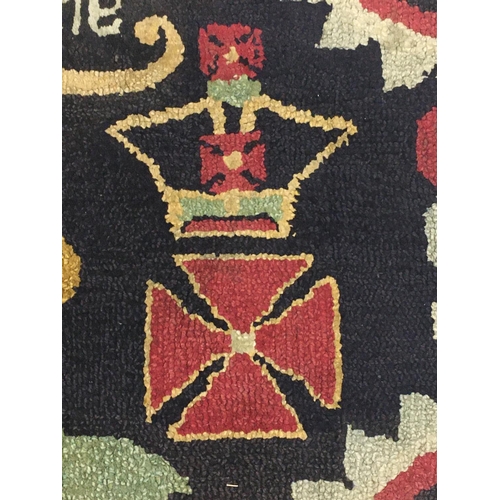 693 - A NAIVE HAND-KNOTTED REGIMENTAL RUG. A rectangular hand knotted woolen rug worked with the motto 'Ho... 