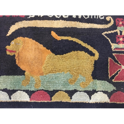 693 - A NAIVE HAND-KNOTTED REGIMENTAL RUG. A rectangular hand knotted woolen rug worked with the motto 'Ho... 