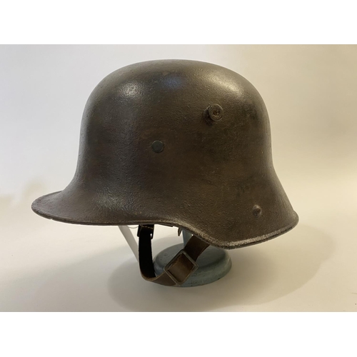 712 - A FIRST WORLD WAR GERMAN M16 STEEL HELMET. In excavated condition with twin lug vents and modern lea... 