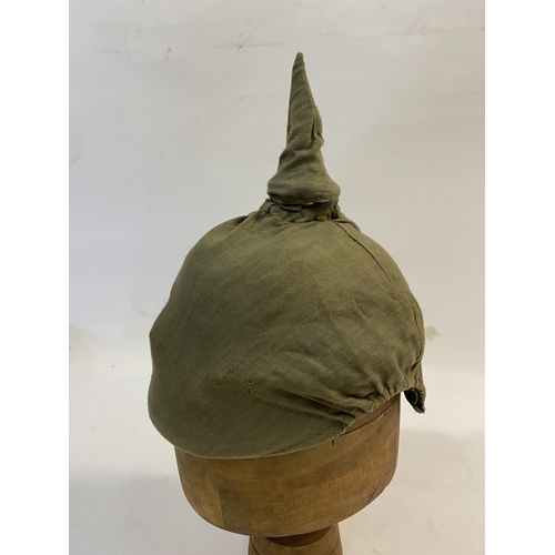 759 - A PRUSSIAN M1915 INFANTRY PICKELHAUBE AND COVER. With a brass spike above five holes on a base plate... 