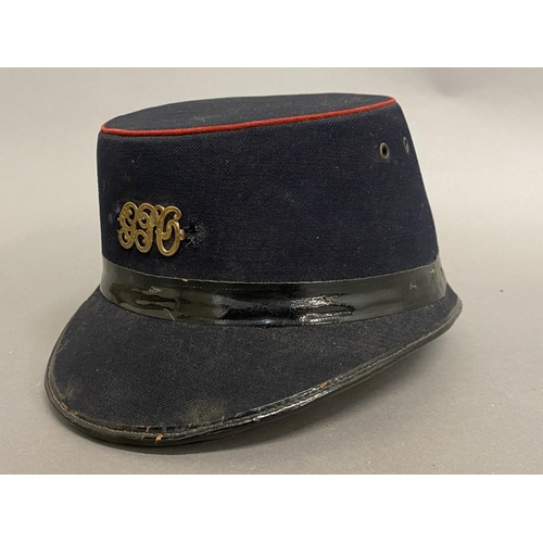 771 - A GEORGE V POST OFFICE CAP. A black fabric 'Shako' style GPO workers hat with oval top with red bead... 