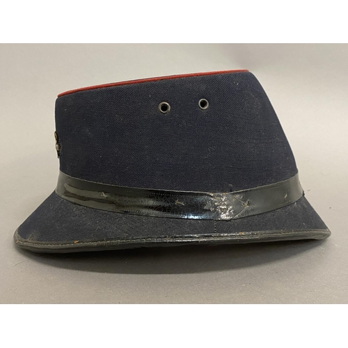 771 - A GEORGE V POST OFFICE CAP. A black fabric 'Shako' style GPO workers hat with oval top with red bead... 