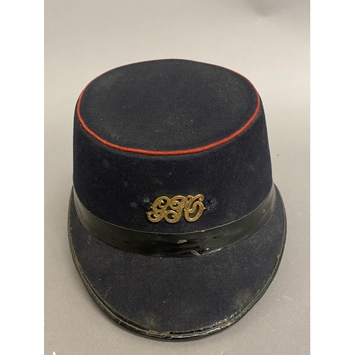 771 - A GEORGE V POST OFFICE CAP. A black fabric 'Shako' style GPO workers hat with oval top with red bead... 