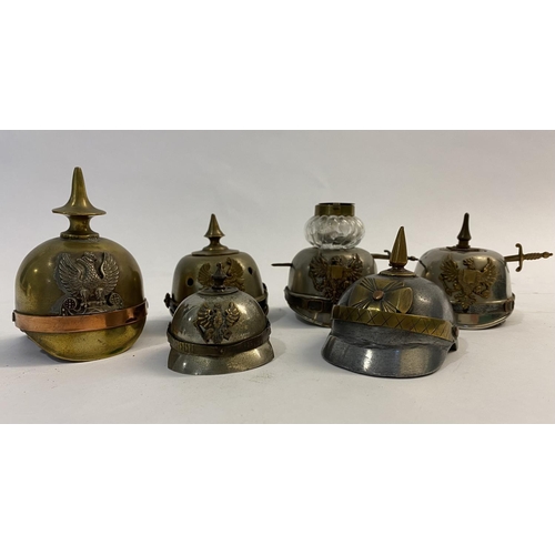 776 - A COLLECTION OF SIX MINIATURE PICKELHAULBES. In brass and plated metals, one mounted as an inkwell w... 