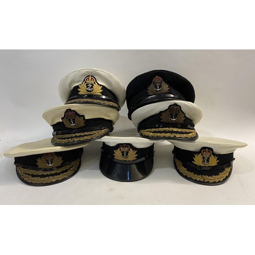 896 - A COLLECTION OF ROYAL NAVY OFFICERS CAPS. A dark blue peaked officers cap with King's Crown by Sande... 