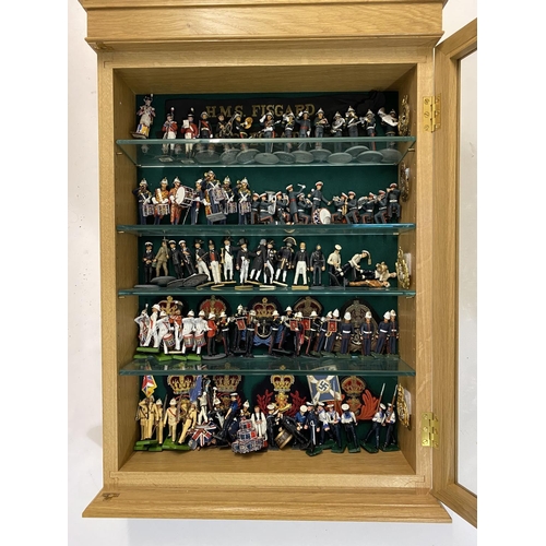 901 - A LARGE COLLECTION OF HAND PAINTED MILITARY FIGURES. A glass fronted oak effect display cabinet cont... 