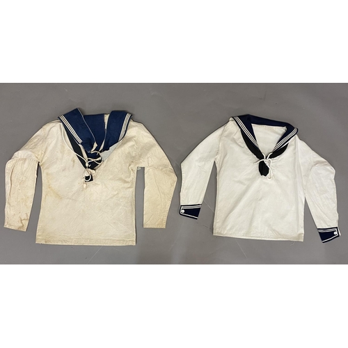 902 - TWO WHITE SAILORS SMOCKS WITH BLUE COLLARS. Two similar white sailors smocks, both with blue collars... 