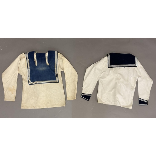 902 - TWO WHITE SAILORS SMOCKS WITH BLUE COLLARS. Two similar white sailors smocks, both with blue collars... 