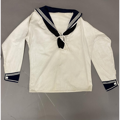 902 - TWO WHITE SAILORS SMOCKS WITH BLUE COLLARS. Two similar white sailors smocks, both with blue collars... 