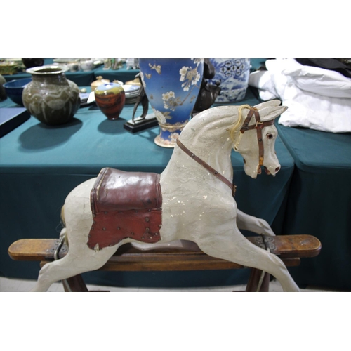 1367 - ANTIQUE ROCKING HORSE a painted rocking horse mounted on a wooden trestle stand, fitted with a saddl... 