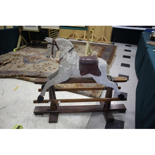 1367 - ANTIQUE ROCKING HORSE a painted rocking horse mounted on a wooden trestle stand, fitted with a saddl... 