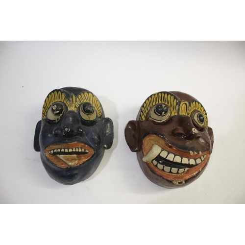 1477 - TWO CEYLONESE TRIBAL MASKS two wooden brightly painted tribal masks, both around 23cms high. Also wi... 