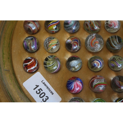 1503 - SOLITAIRE & MARBLES a qty of mostly hand blown latticino core swirl marbles, mounted on a wooden sol... 