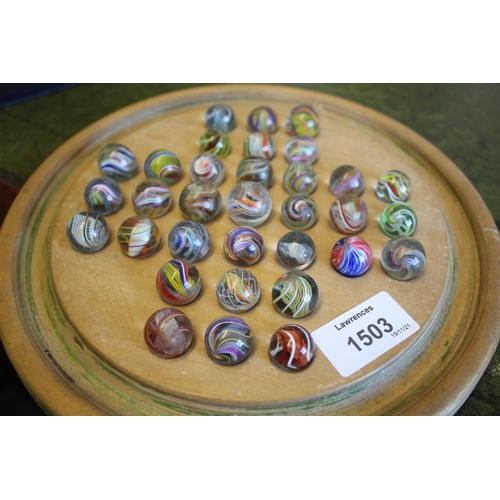 1503 - SOLITAIRE & MARBLES a qty of mostly hand blown latticino core swirl marbles, mounted on a wooden sol... 