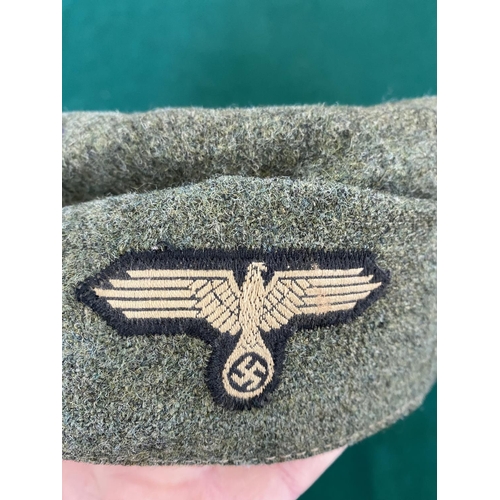 681 - A SECOND WORLD WAR OR LATER 'SS TOTENKOPF' CAP. A green fabric forage cap with skull and cross bones... 