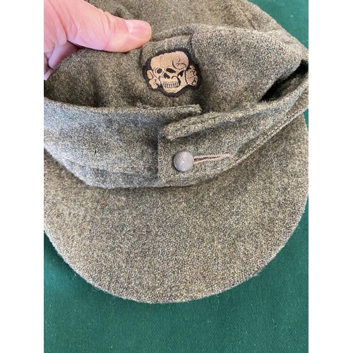 681 - A SECOND WORLD WAR OR LATER 'SS TOTENKOPF' CAP. A green fabric forage cap with skull and cross bones... 