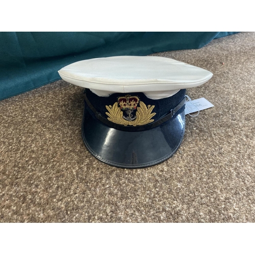 896 - A COLLECTION OF ROYAL NAVY OFFICERS CAPS. A dark blue peaked officers cap with King's Crown by Sande... 