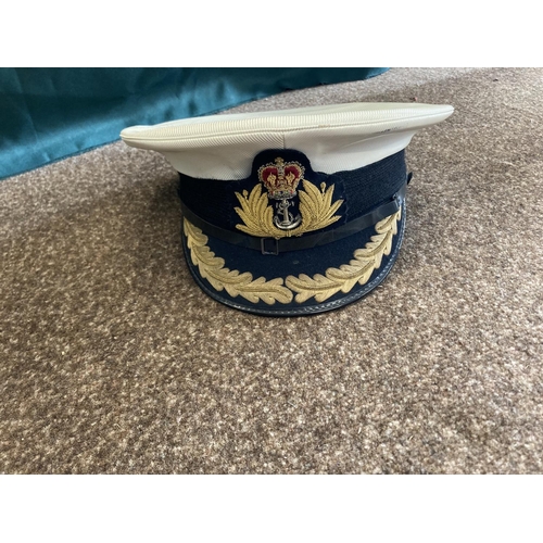 896 - A COLLECTION OF ROYAL NAVY OFFICERS CAPS. A dark blue peaked officers cap with King's Crown by Sande... 