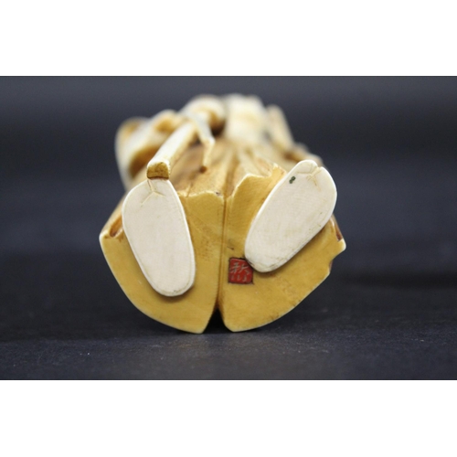1104 - JAPANESE SIGNED IVORY OKIMONO - OKUBO Meiji period, a detailed carved ivory of a gentleman, holding ... 