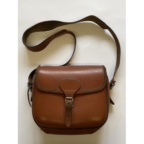 471 - A BROWN LEATHER CARTRIDGE BAG. A light brown shoulder cartridge bag with buckle fastening and should... 