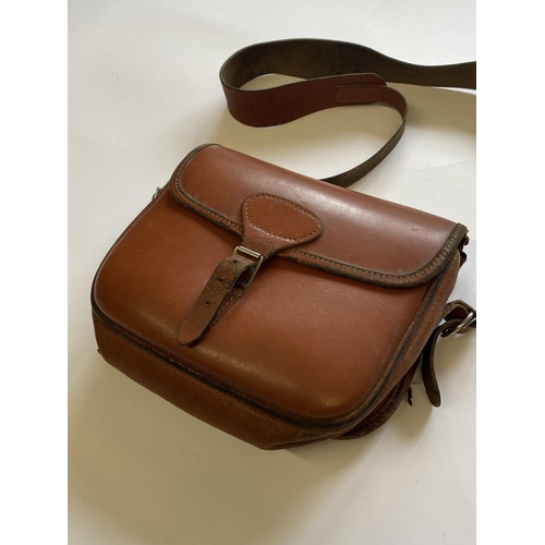 471 - A BROWN LEATHER CARTRIDGE BAG. A light brown shoulder cartridge bag with buckle fastening and should... 