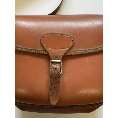 471 - A BROWN LEATHER CARTRIDGE BAG. A light brown shoulder cartridge bag with buckle fastening and should... 