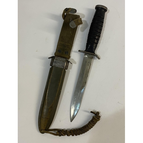 545 - A US M3 FIGHTING KNIFE AND SCABBARD BY UTICA. With a 17cm pointed blade with double sided point, the... 