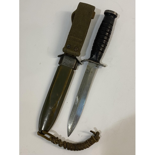 545 - A US M3 FIGHTING KNIFE AND SCABBARD BY UTICA. With a 17cm pointed blade with double sided point, the... 