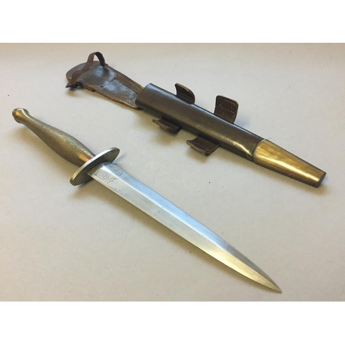 558 - A WILKINSON SWORD CO. FAIRBURN SYKES FIGHTING KNIFE AND SCABBARD. With a 16.5cm double sided pointed... 