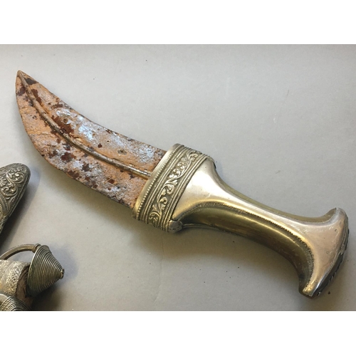 567 - A YEMEN JAMBIYA TYPE DAGGER AND SHEATH. With an 18cm curved blade with central rib, the white metal ... 