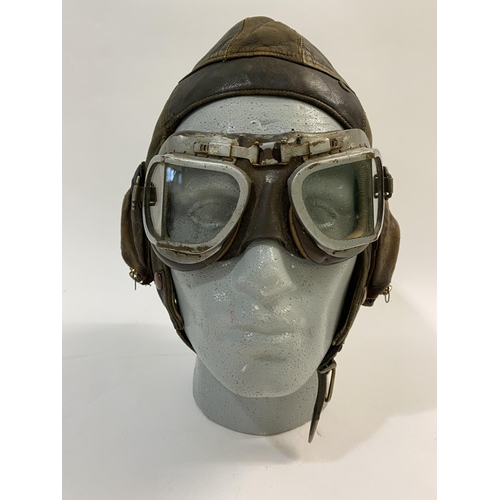 601 - A SECOND WORLD WAR PILOTS FLYING HELMET AND PEAKED CAP. A Type B flying helmet, 1936-41 with a pair ... 