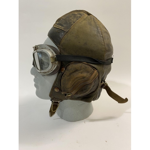 601 - A SECOND WORLD WAR PILOTS FLYING HELMET AND PEAKED CAP. A Type B flying helmet, 1936-41 with a pair ... 