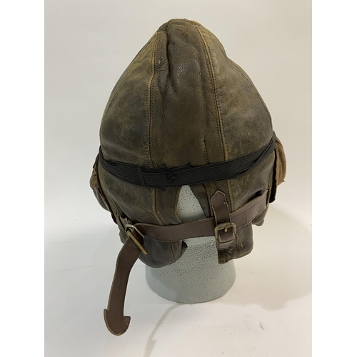 601 - A SECOND WORLD WAR PILOTS FLYING HELMET AND PEAKED CAP. A Type B flying helmet, 1936-41 with a pair ... 