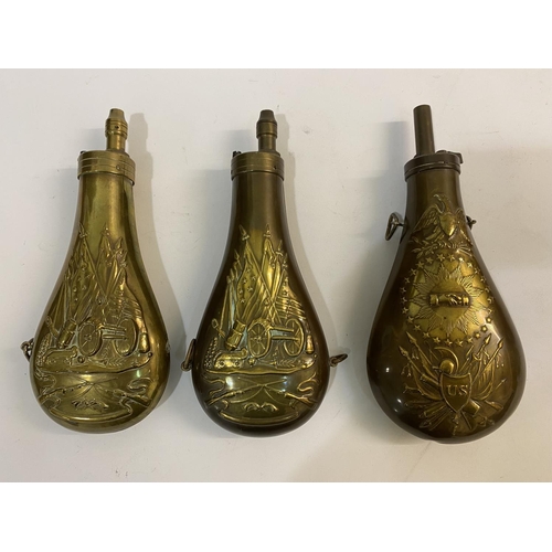 675 - THREE COPPER AND BRASS POWDER FLASKS WITH AMERICAN THEMED DECORATION. A copper powder flask embossed... 