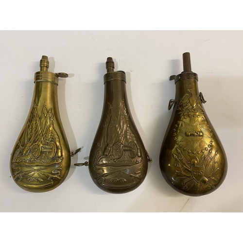 675 - THREE COPPER AND BRASS POWDER FLASKS WITH AMERICAN THEMED DECORATION. A copper powder flask embossed... 