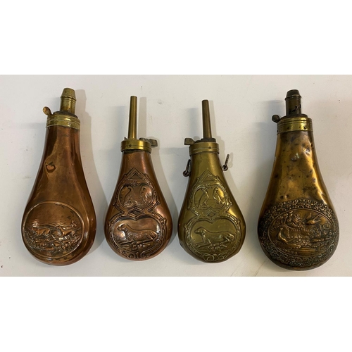 676 - A COLLECTION OF FOUR BRASS AND COPPER POWDER FLASKS. Four similar brass and copper powder flasks emb... 