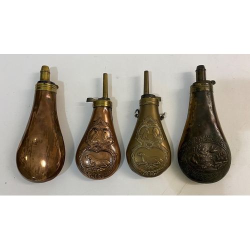 676 - A COLLECTION OF FOUR BRASS AND COPPER POWDER FLASKS. Four similar brass and copper powder flasks emb... 