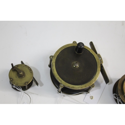 2138 - ARMY & NAVY BRASS REELS including a 4' brass reel with wooden winder, and a 2 3/4' reel with ebonise... 